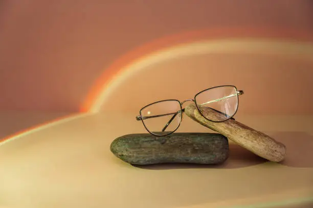 Photo of Vision glasses with black frames on stones under orange light