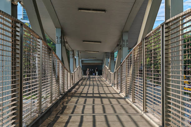 istock Rear people walk across bridge with light shade to access office 2045707974