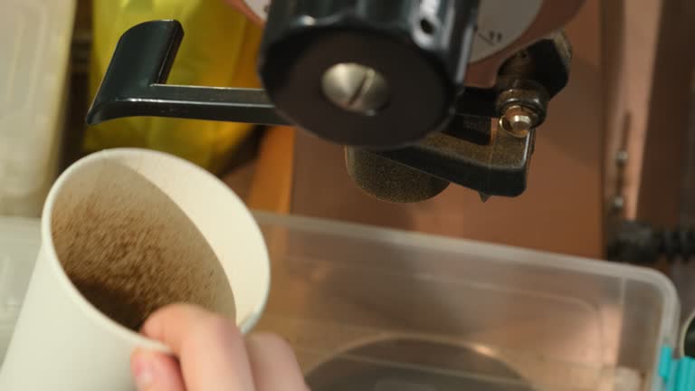 Man uses grinding machine for making grounded coffee