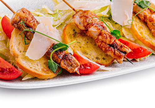 trendy Caesar salad with chicken on wooden skewers