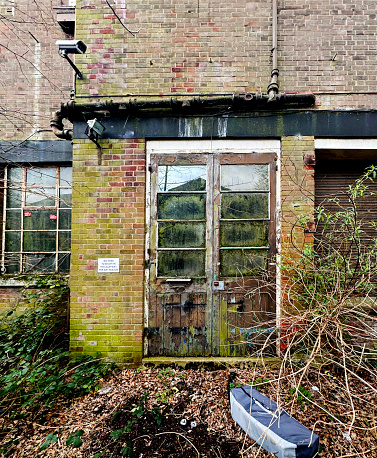Overgrown door on an abandoned old factory