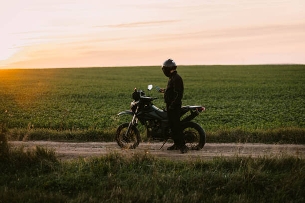istock motorcyclist on an enduro motard motorcycle in a field at sunset 2045763581