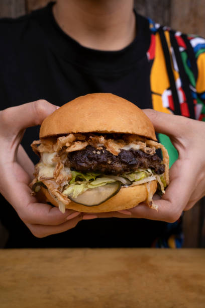 istock A woman holding a giant burger 2045770002