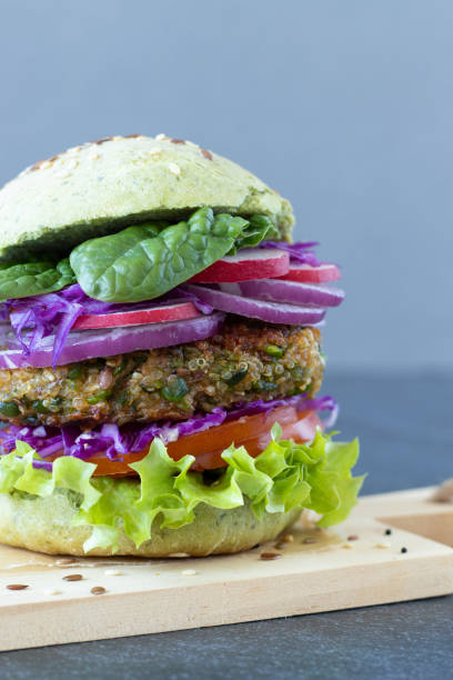 istock Vegan sandwich with lettuce, tomato, onion, spinach and red cabbage, vertical close-up. 2045774332