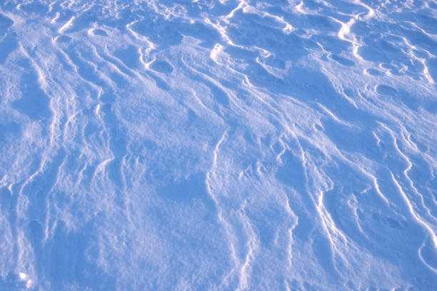 istock drawing on the surface of a snowy plain, created by the wind, illuminated by the setting sun 2045784359