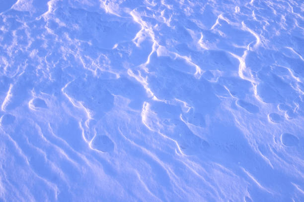 abstraction background. Snow with patterns created by the wind and illuminated by the sun close-up.