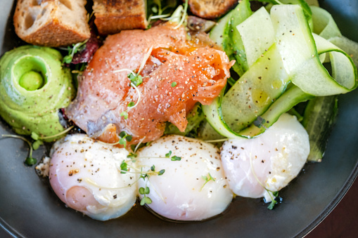 poached eggs with smoked salmon, avocado and cucumber on a plate