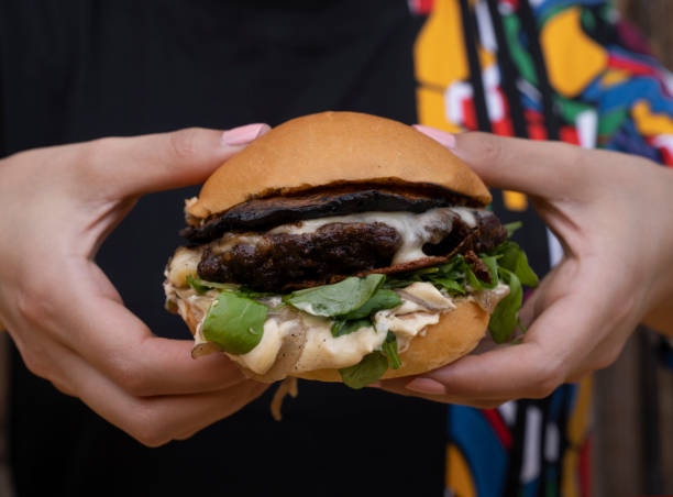 A woman holding a mushrooms burger
