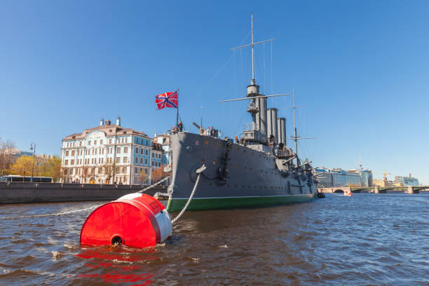 St-Petersburg, Russia - May 21, 2022: Aurora is a Russian protected cruiser is moored on Neva river in St.Petersburg, currently preserved as a museum ship. Visitors are on the upper deck