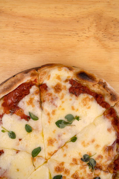 Traditional mozzarella cheese pizza with tomato sauce, fresh oregano leaves and olive oil.