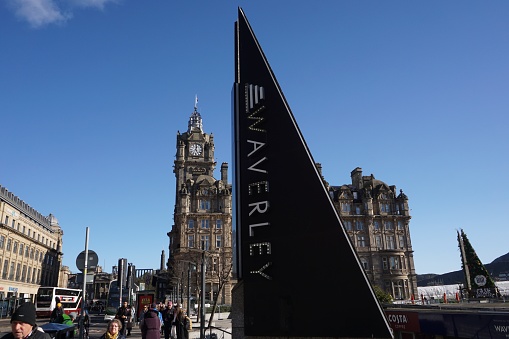 Edinburgh, Scotland - 26 February 2024:  A striking sign for the Waverley Market on Prices Street contrasts with the Balmoral Hotel behind it.