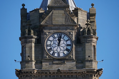 Edinburgh, Scotland - 26 February 2024: The famous clock on the Balmoral Hotel above Waverley station, which is kept a few minutes fast to help travellers.