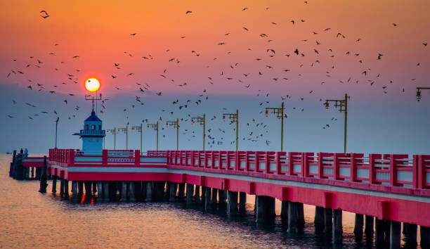 Scenic view red pier with lighthouse at sunrise in Thailand.