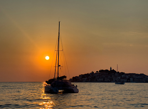 Sunset. Summer. Catamaran. Sailing yacht. Adventure. Sea. Yachting. Evening.