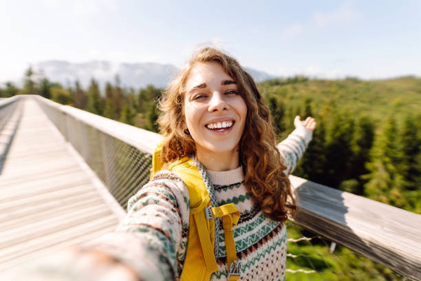 istock Happy tourist walking and takes selfie using smartphone camera. 2045845996
