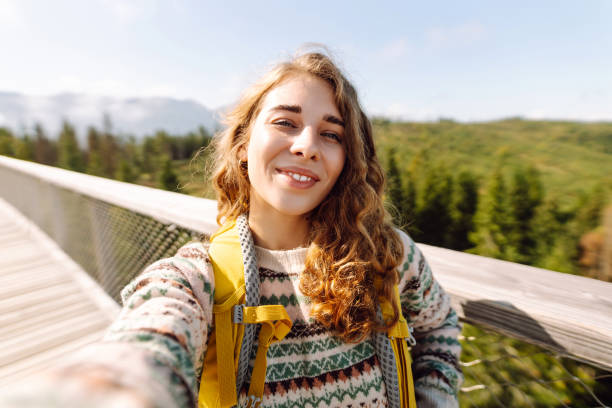 istock Happy tourist walking and takes selfie using smartphone camera. 2045846436