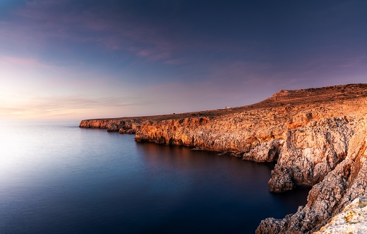 Landscape view of cliffs and rugged shorelina at Pont d'en Gil in northeastern Menorca near Ciutadella at sunset