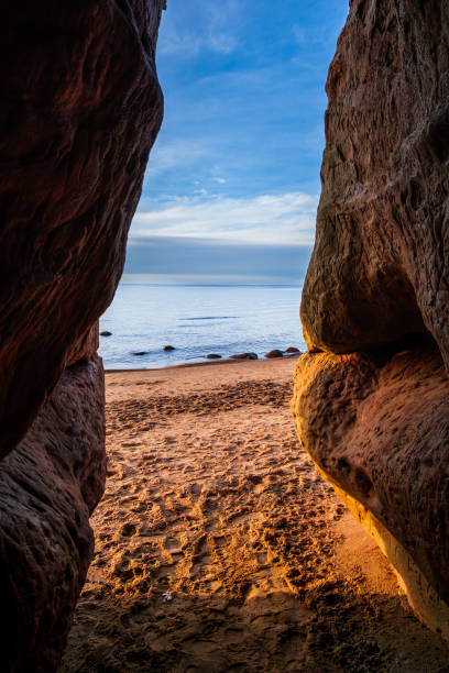 istock Coastal Sanctuary: Sunset Reflections in Veczemju Klintis Cave 2045875457