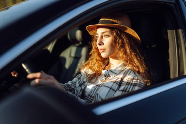 istock Beautiful young woman driving her car. 2045887562