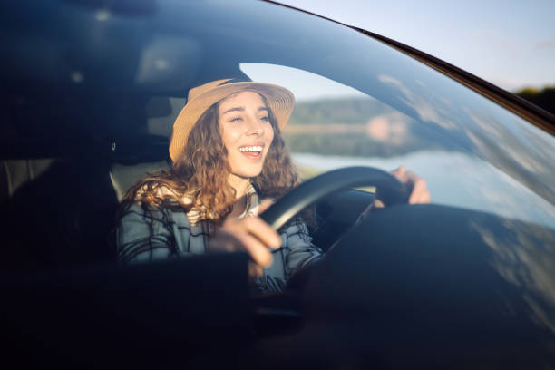 istock Beautiful young woman driving her car. 2045887567