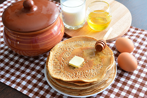 pancakes on the plate with butter, honey and milk