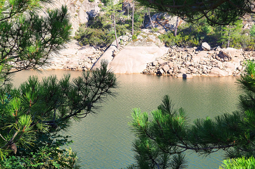 Near Porto-Vecchio, in the heart of Alta Rocca, a true stone citadel, Lake U Spidali is nestled between road and mountains. Due to successive droughts, the water level has dropped enormously, revealing the stumps of trees felled before impoundment.