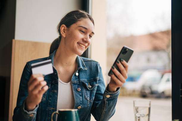 istock Young beautiful girl using credit card and smart phone. 2045949088