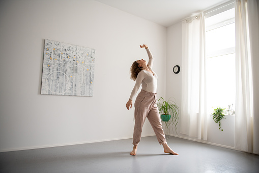 Woman practicing Feldenkrais method through the movement  and doing yoga at home. Zen vibe, breathing relaxing exercises.