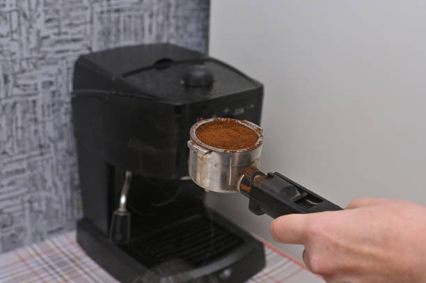 istock a woman's hand puts ground coffee in the coffee machine 2045958002