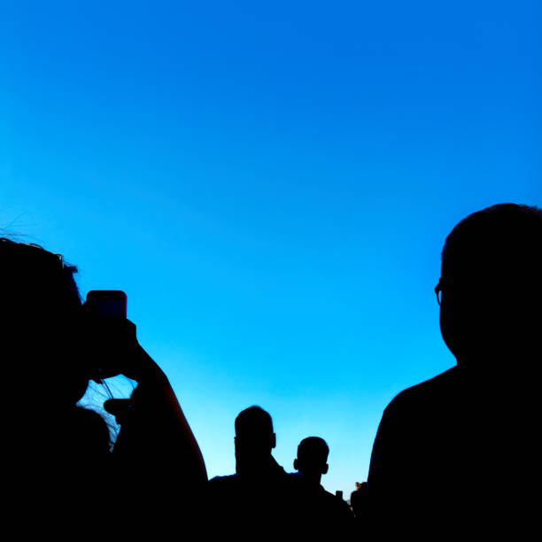 Crowd of people recording with mobile phone during public event