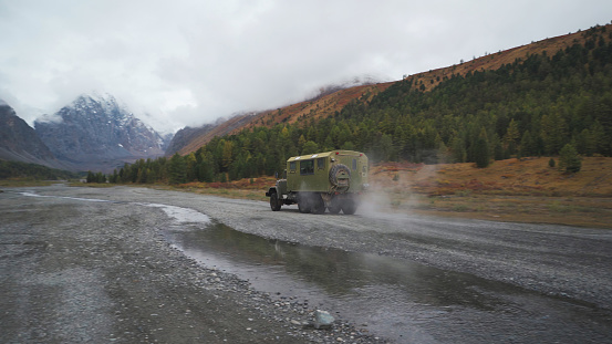 A military truck is driving toward the mountain. Altai republic