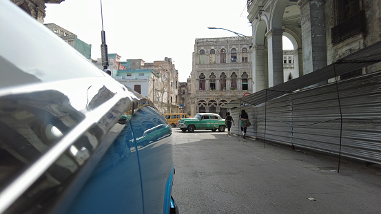 POV through old vehicle to city street in Havana City