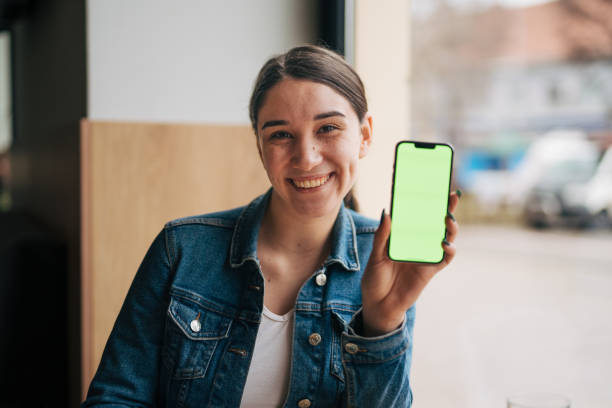 Young woman with green screen phone