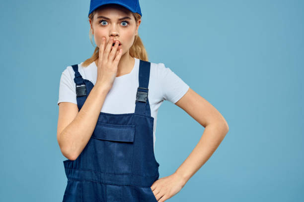 istock Woman in work uniform blue cap carriage delivery service courier blue background 2046019631