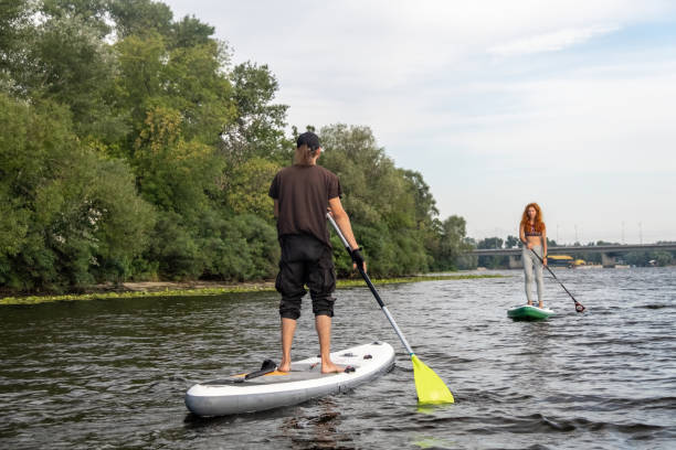 istock Man and woman balance on paddleboards on summer weekend 2046028057