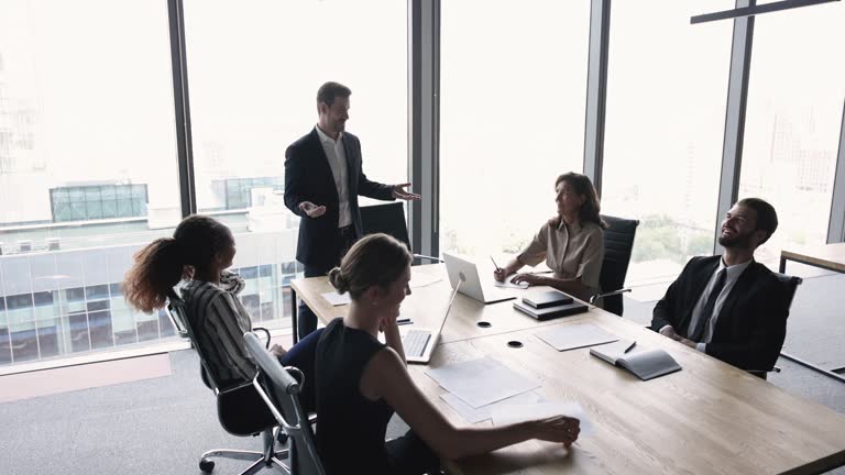 Diverse team of positive business colleagues meeting in contemporary office