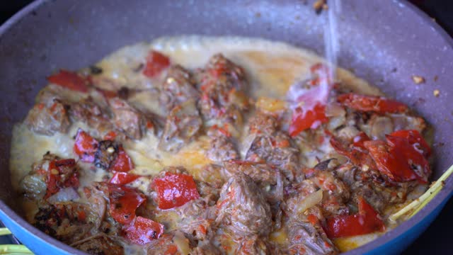 Frying pan with onion, lemongrass, red pepper and beef meat, close up. Indonesia
