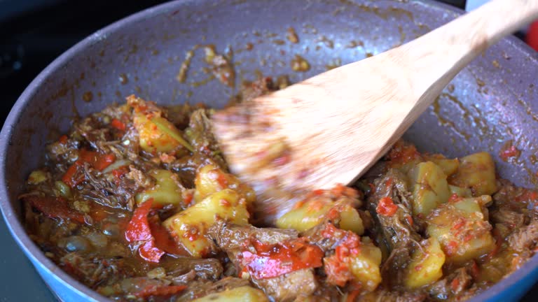 Frying pan with onion, lemongrass, red pepper and beef meat, close up. Indonesia