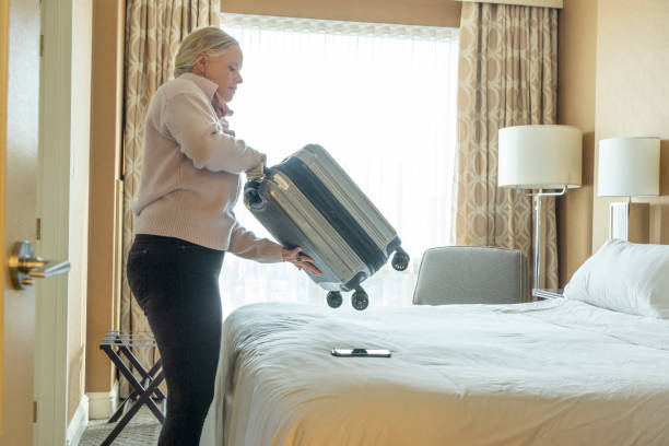istock Mature woman opens suitcase on bed 2046096266