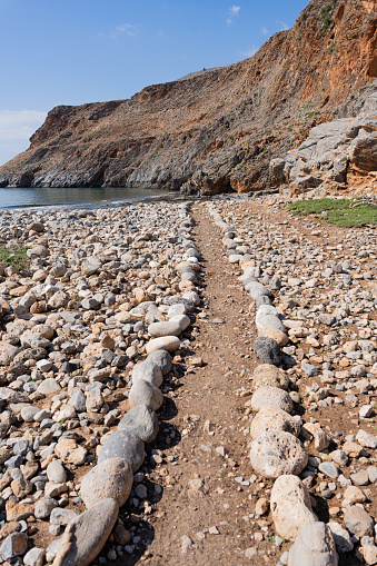 Beautiful and simple path made with stones or pebbles, a wild area to guide walkers on their visit to the wild coast of Crete