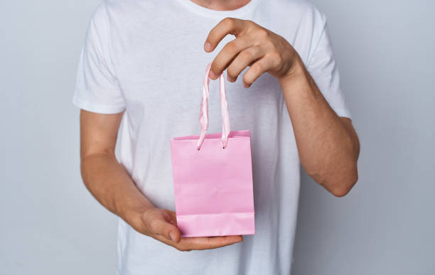 istock model man with gift bag in hand on light background holidays 2046129621