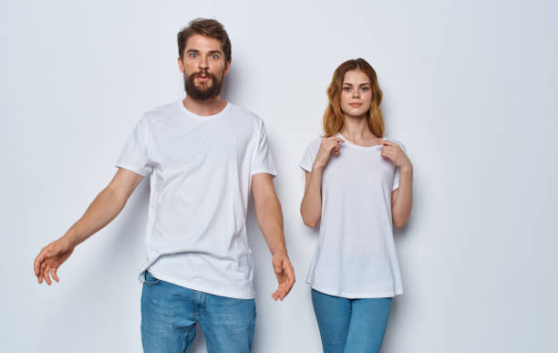 istock A guy and a beautiful woman in the same clothes on a light background are gesticulating with their hands 2046161561