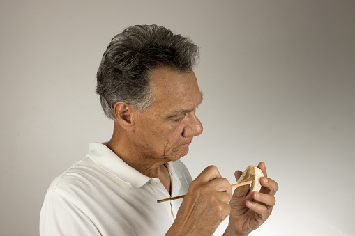 Dental Tech closely examining the mold or impression of a patients lower teeth