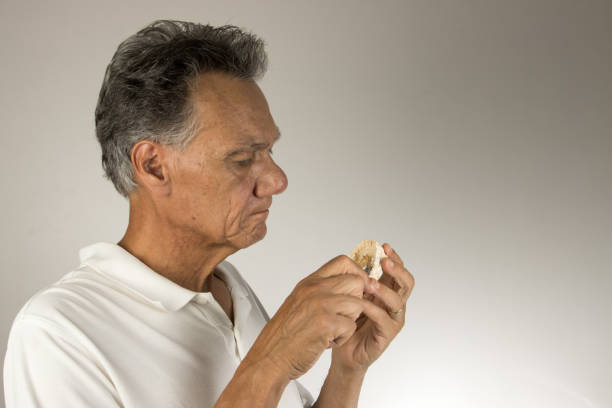 Dental Tech closely examining the mold or impression of a patients lower teeth