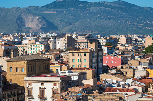 This image showcases a sprawling Palermo cityscape in Sicily, Italy, against a backdrop of a Pellegrino mountain and stunningly clear blue sky. A stunning view of the vibrant cityscape of Palermo, Sicily, Italy, unfolds against the backdrop of majestic mountains under a clear blue sky, capturing the essence of this historic Italian city