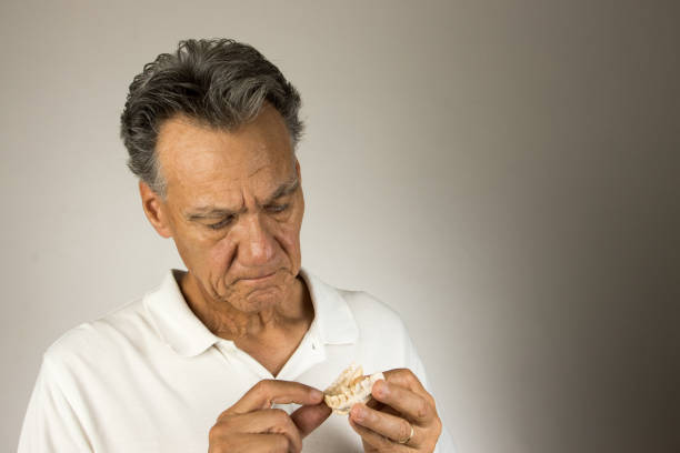 istock Dental Tech examining the mold of a persons teeth 2046185587