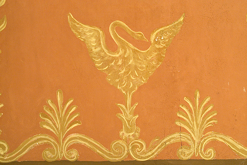 Orange wall with a drawing of a bird in gold tones in vintage style
