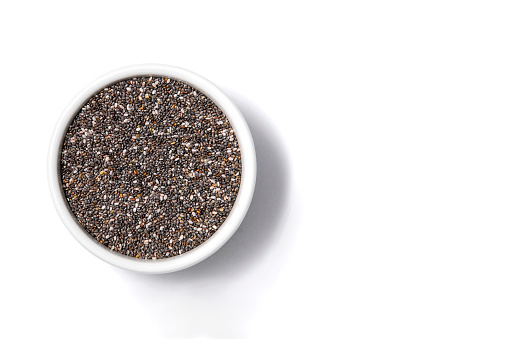 Poppy seed in a bowl viewed from above on a white background with space for text, medicinal use