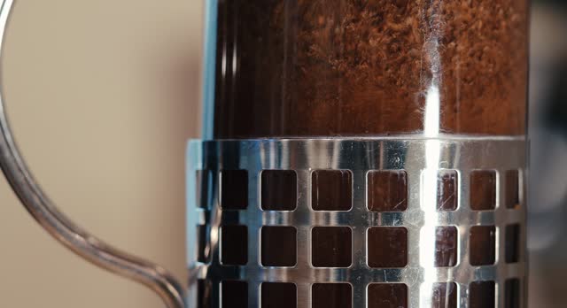 Closeup shot of Filling a French press for coffee with hot water