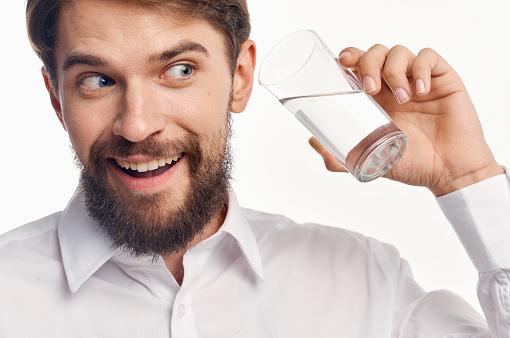 portrait of a man with a glass of transparent water healthy lifestyle drink. High quality photo